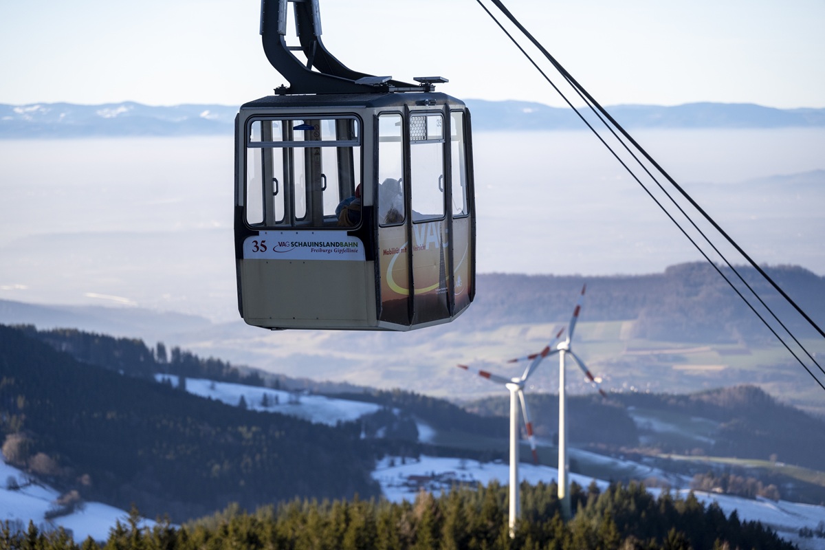 Eine Gondel der Schauinslandbahn, im Hintergrund der Schauinsland und zwei Windräfer.