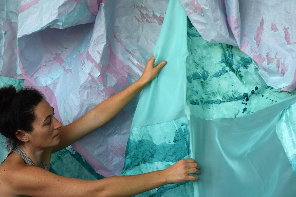 Olga Jakob präsentiert ihr Werk, das einen grün-violetten Stoff darstellt.