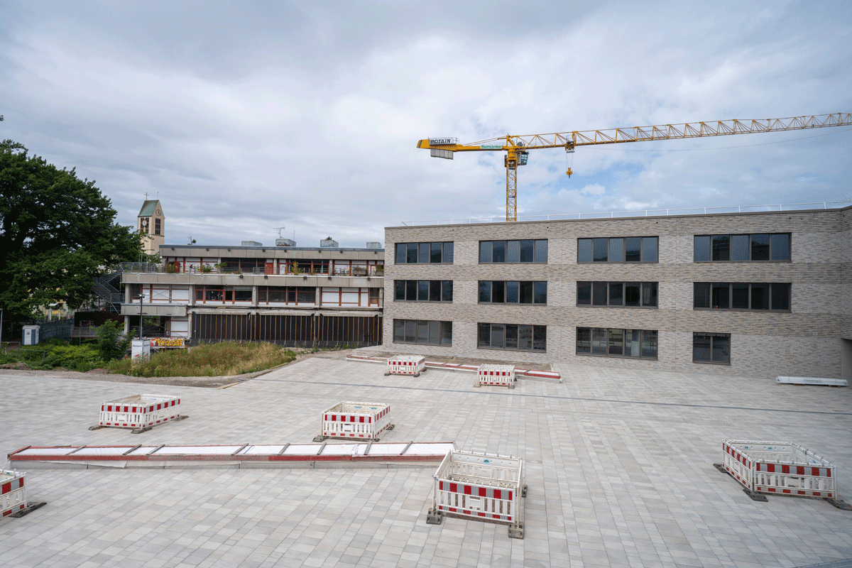 Rechts Neubau, links Altbau, im Vordergrund Schulhof