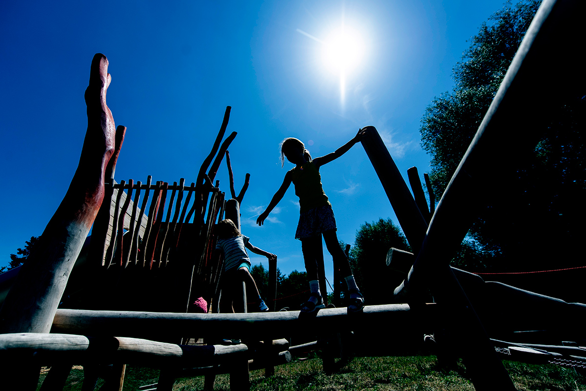 Mädchen bei Sonnenschein auf einem Klettergerüst