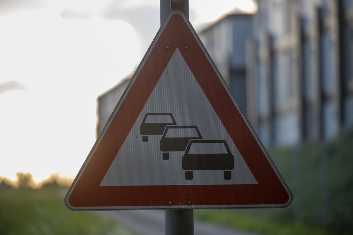 Straßenschild mit drei Autos, das Stau bedeutet.