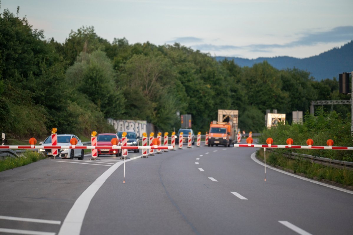 Straßensperrung vor dem Tunnel, im Hintergrund Autos