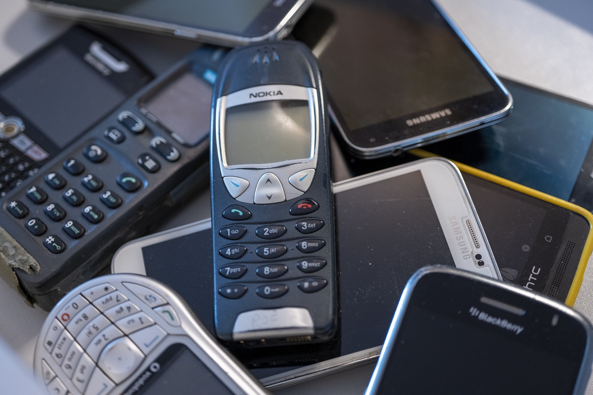 Ein Haufen alter Handys in einer Schublade.