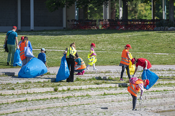Engagierte sammeln mit Zangen Müll im Seepark ein