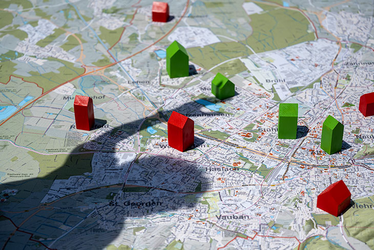Stadtkarte mit kleinen "Monopolyhäusern"