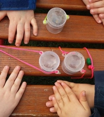 Hände von Kindern mit Lupengläsern.