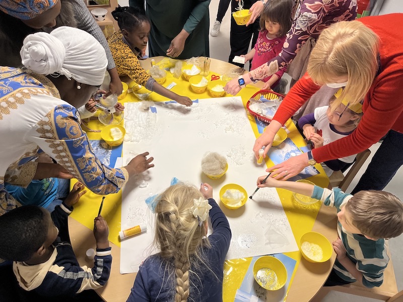 Gemeinsam mit den Eltern entsteht eine Schneelandschaft.