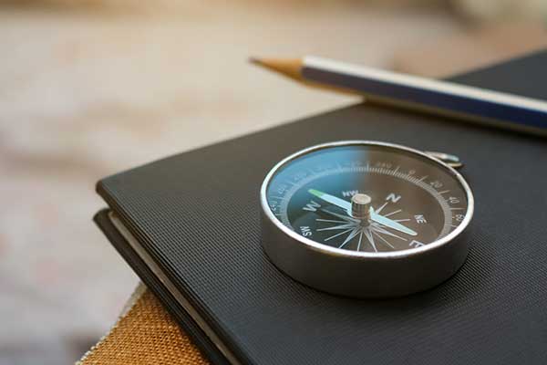 Kompass, Notizheft und Stift