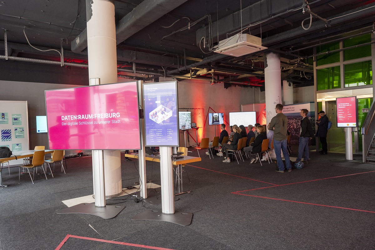 Bildschirme und Menschengruppe in einem Raum