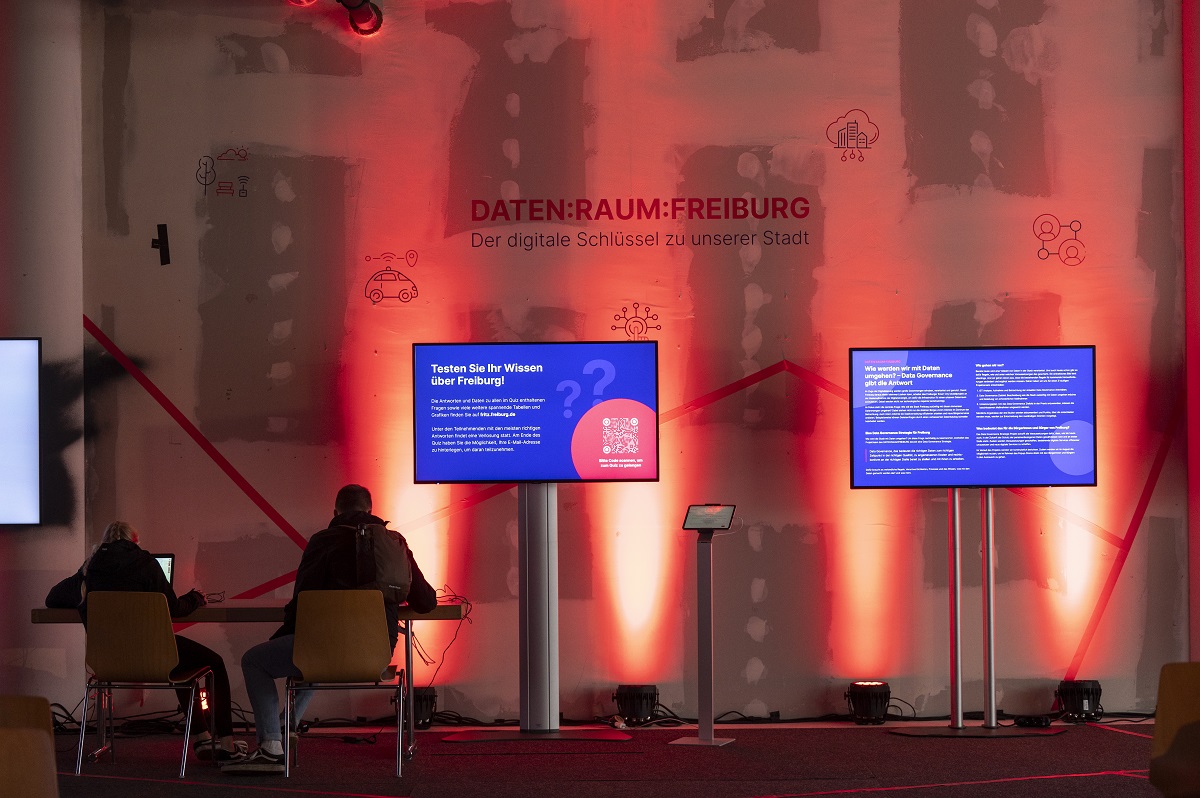 Bilschirme vor einer beleuchteten Wand