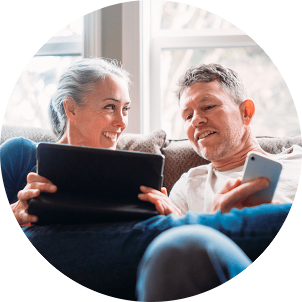 Frau und Mann mit Laptop und Smartphone auf dem Sofa