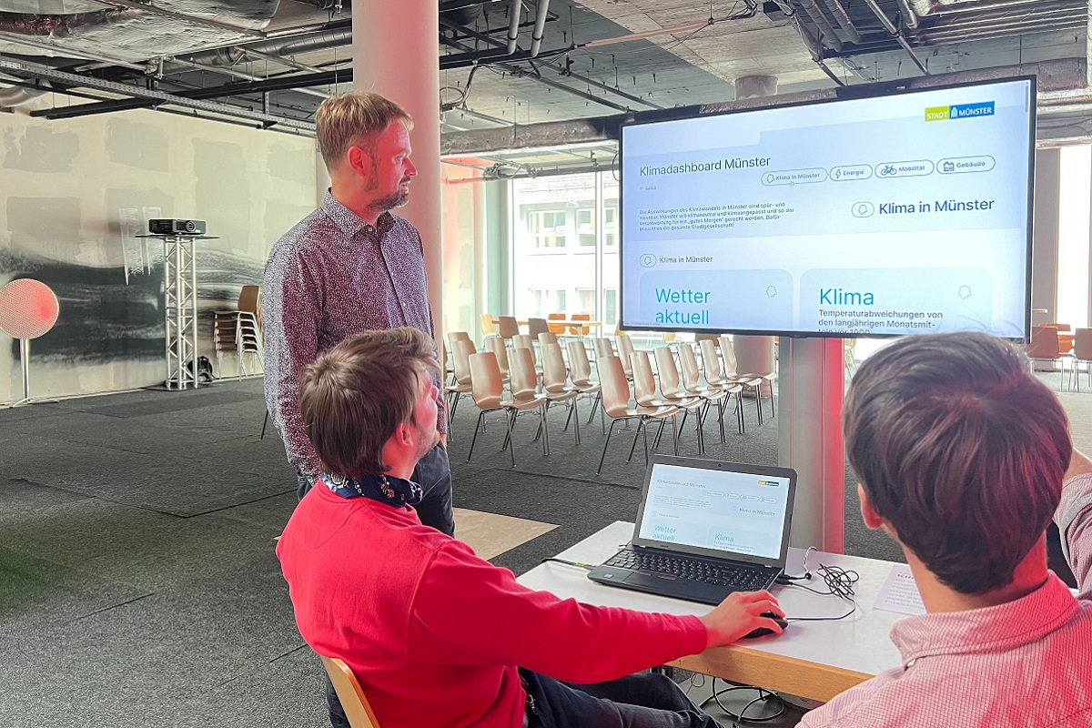 Drei Menschen vor einem Bildschirm