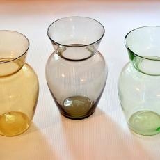 3 Wasen aus Glas. Von links nach rechts ist die erste gelbfarben, die zweite grau und die dritte grün.
