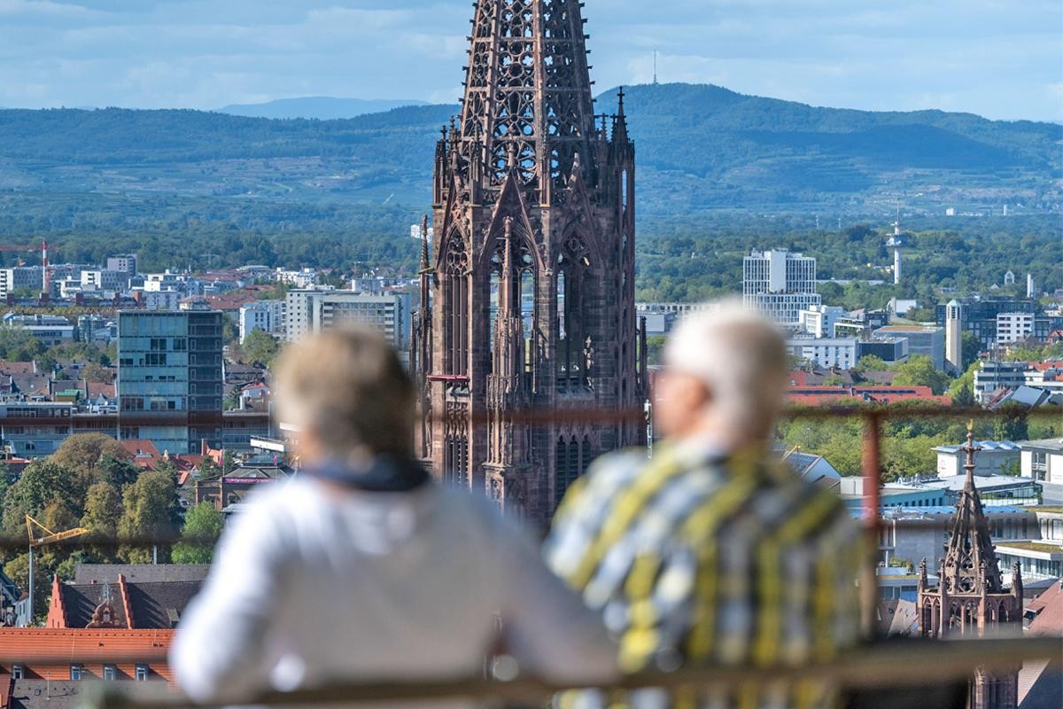 Älteres Paar auf einer Bank mit Blick über Freiburg