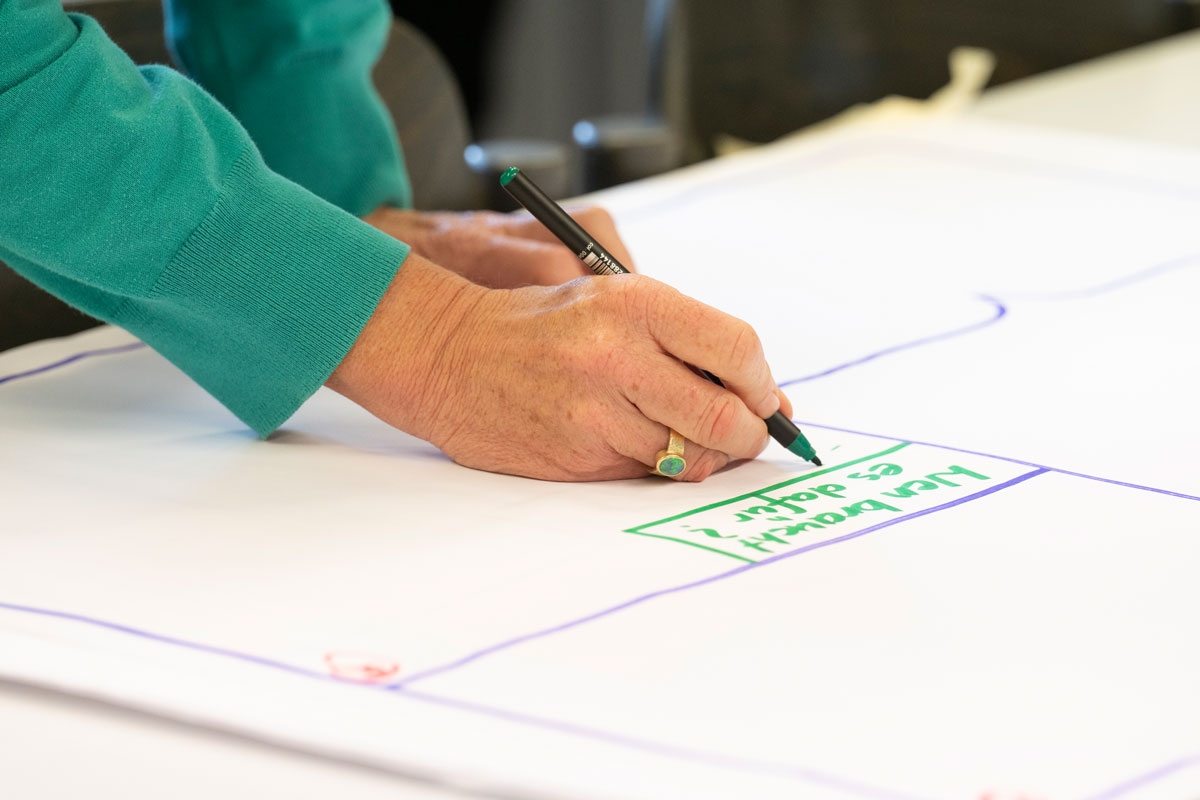 Person schreibt etwas auf ein Blatt Papier