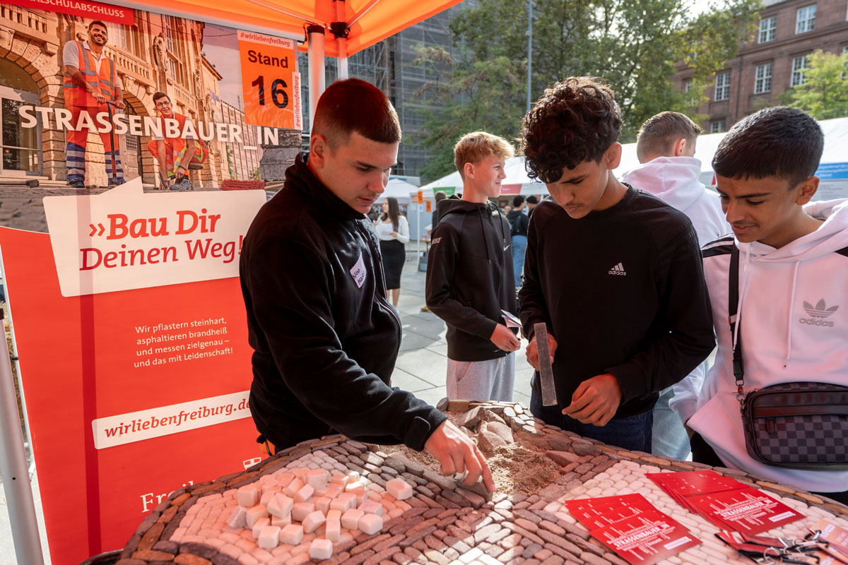 Mehrere Personen stehen um einen Stand