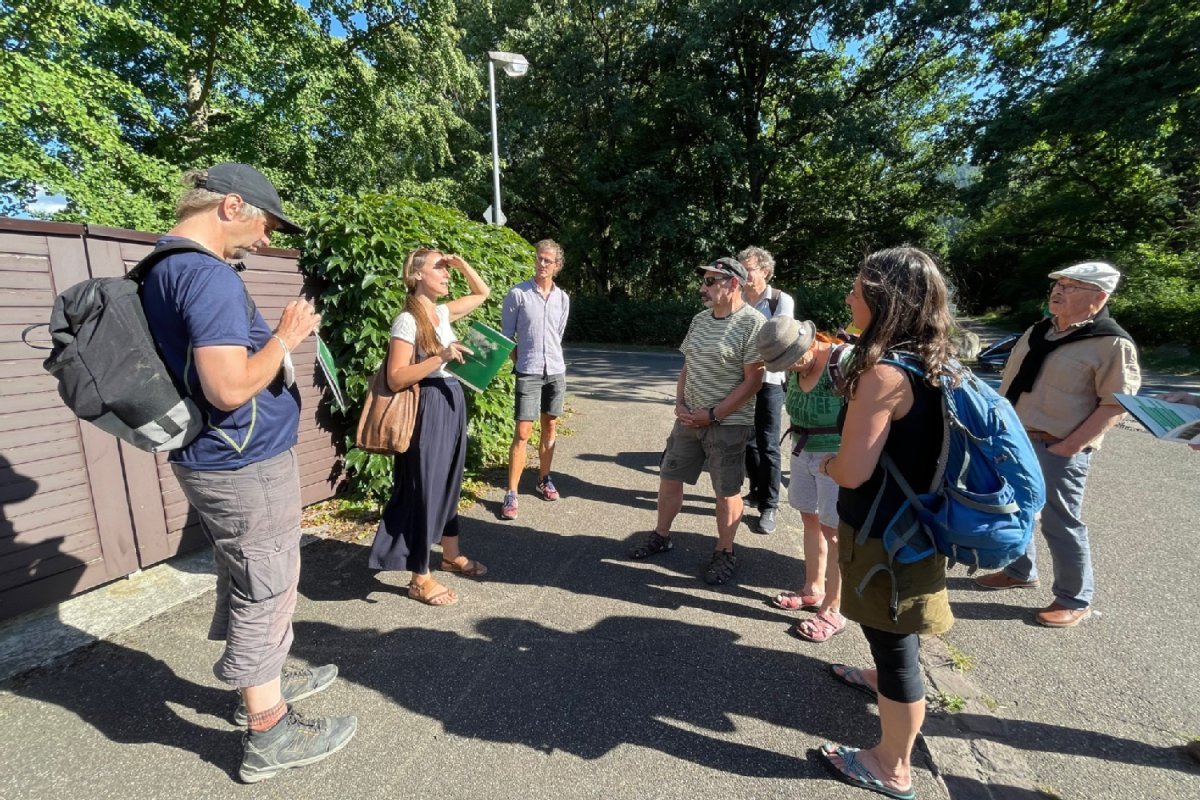 Personengruppe vor einer begrünten Mauer