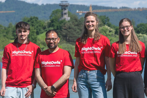 Zwei Männer und zwei Frauen in roten T-Shirts mit der Aufschrift "Night Owls - Die NachtMediator_innen"